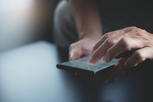 man zoekt iets op zijn telefoon